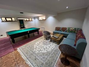 a living room with a couch and a pool table at HOTEL DEHLAVI o in Dushanbe