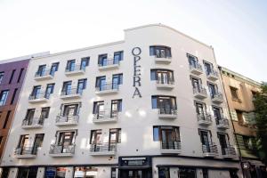 a white building with a sign on it at Opera Hotel in Timişoara