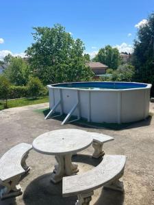 - une table de pique-nique et deux bancs en face d'une piscine dans l'établissement Casa con jardín en Escalona, à Escalona