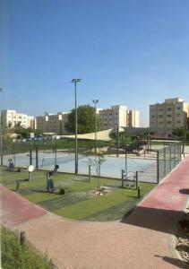 a park with a tennis court in a city at شروق المدينة - مدينة الملك عبدالله الاقتصادية in King Abdullah Economic City