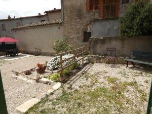 een tuin met een bank en bloemen voor een gebouw bij SCAPPO IN UMBRIA, Vicoletto in Porchiano