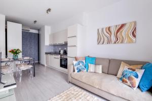 Rames-Cosmo Downtown Apartment with rooftop POOL في بودابست: غرفة معيشة مع أريكة ومطبخ