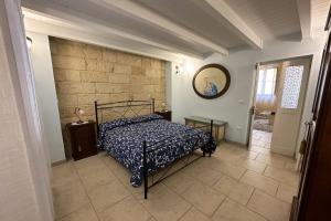 una camera con letto e muro di mattoni di Casa Begi a Guagnano