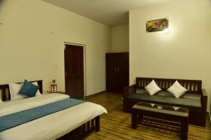 1 dormitorio con cama y banco. en Corbett Wala Home Stay, en Rāmnagar