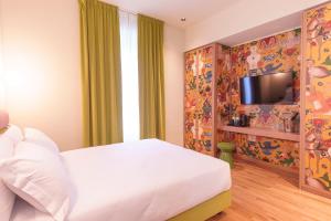 a bedroom with a white bed and a tv at Hotel Marisa in Rome