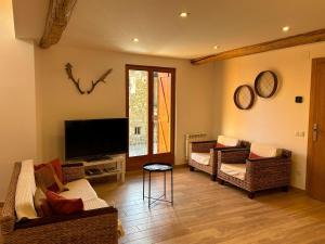 a living room with couches and a flat screen tv at CasaCo Llessui in Llesúy