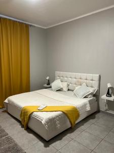 a bedroom with a large bed with a yellow blanket at شروق المدينة - مدينة الملك عبدالله الاقتصادية in King Abdullah Economic City