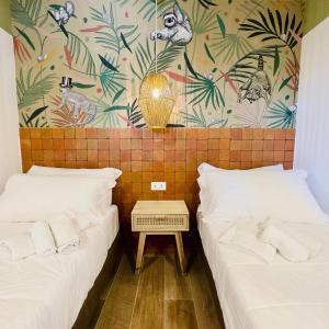 a room with two beds and a wall with plants at Le Palme Village in Terracina