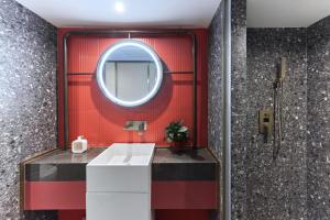 uma casa de banho com uma parede vermelha e um espelho em M Hotel - Beijing Tiananmen Square Qianmen Subway Station em Pequim