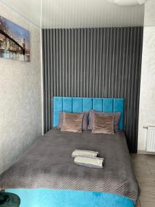 ein großes Bett mit blauem Kopfteil in einem Zimmer in der Unterkunft Гостевой дом in Tschernihiw