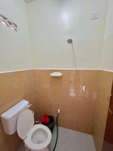 a bathroom with a toilet with a hose at Roomstay Ehsan in Pekan