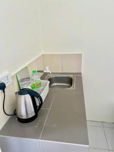 a kitchen counter with a sink and a toaster at Roomstay Ehsan in Pekan