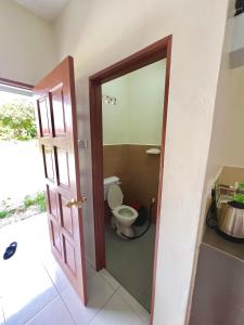 a bathroom with a toilet and a door open at Roomstay Ehsan in Pekan