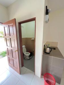 a bathroom with a toilet and a door to a room at Roomstay Ehsan in Pekan