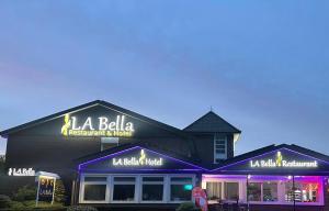 een restaurant met paarse lichten aan de voorzijde bij La Bella in Garrel