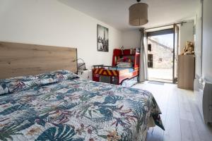 Schlafzimmer mit einem Bett und einer Glasschiebetür in der Unterkunft Gite du Moulin in Saint-Laurent-dʼAndenay