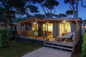 een huis met een terras met een stoel erop bij hu Park Albatros Village in San Vincenzo