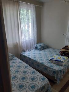 2 camas individuales en una habitación con ventana en Erdek Özlem Pansiyon en Erdek