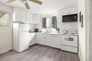 uma cozinha branca com electrodomésticos brancos e armários brancos em Relaxing 2BR Lakehouse by CozySuites em Copake