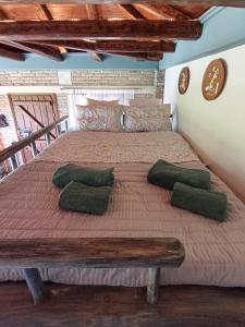 a bedroom with a large bed with green pillows at The Mushroom Cottage in Anilio Pelion