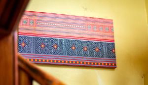 a piece of art hanging on a wall at La Casa Nostra in Luang Prabang