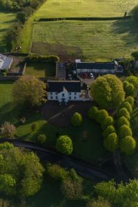 uma casa no meio de um campo com árvores em The Carriage Houses at Beechpark House em Bunratty