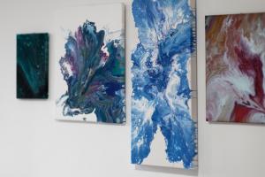 a group of four paintings hanging on a wall at City Central Garden Apartments at Benson Street in Liverpool