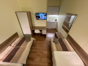 two beds in a small room with a tv at Noclegi nad Obrą in Skwierzyna