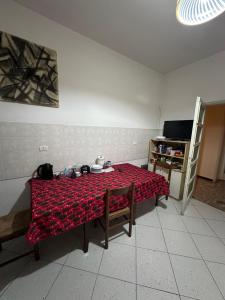 布雷西亞的住宿－Room Via Solferino 17 Brescia，一间房间,桌子上挂着红色毯子