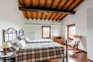 sypialnia z 2 łóżkami i drewnianym sufitem w obiekcie Villa Teresa - Villa & Piscina immersi nel vigneto! w mieście Montecalvo Versiggia
