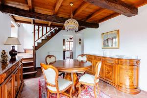 una sala da pranzo con tavolo e sedie in legno di Villa Teresa - Villa & Piscina immersi nel vigneto! a Montecalvo Versiggia