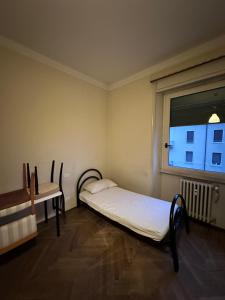 a small room with a bed and a window at Solferino 17 suites Brescia Stazione in Brescia