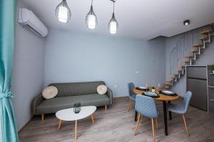 a living room with a couch and a table and chairs at AthmosphereVillaEma Apartments in Kranevo