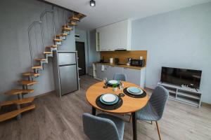 a kitchen and dining room with a table and a spiral staircase at AthmosphereVillaEma Apartments in Kranevo