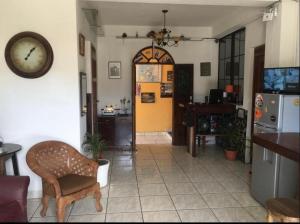 uma sala de estar com um relógio na parede em Hotel central em San Juan del Sur