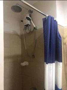 y baño con ducha con cortina azul. en Field Residences Condotel Near Airport, en Manila