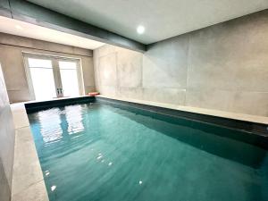 uma grande piscina num quarto com janela em 5 Bed Luxury House with Swimming pool em Chepstow