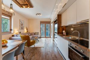 eine Küche und ein Wohnzimmer mit einer Couch in der Unterkunft Zlatibor Centar Lux Apartman in Zlatibor + 18 Fotos