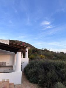 una casa blanca con una colina en el fondo en Country Houses Monte delle Cristule, en Lipari