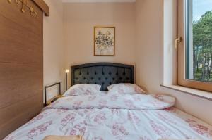 ein Schlafzimmer mit einem großen Bett mit Fenster in der Unterkunft Zlatibor Centar Lux Apartman in Zlatibor