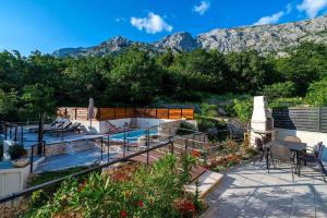a patio with a pool and mountains in the background at Villa Didovina mit Pool und Meerblick in Tučepi