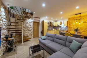 a living room with a couch and a spiral staircase at Villa Didovina mit Pool und Meerblick in Tučepi