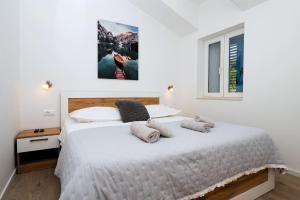 a bedroom with a large white bed with two pillows at Villa Didovina mit Pool und Meerblick in Tučepi +30 photos