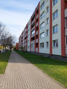 an empty sidewalk in front of a building at trendy in Ventspils