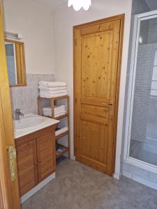 baño con lavabo y puerta de madera en La maison de Clémentine, en Héricy