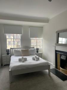 a white bedroom with a bed and a fireplace at Pass the Keys Modern 3 Bed Flat on the Historic Royal Mile in Edinburgh