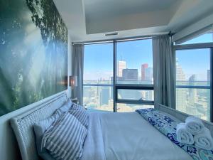 a bedroom with a bed with a view of the city at waterfront Executive INN in Toronto