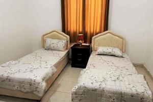 duas camas sentadas uma ao lado da outra num quarto em Beautfiul Salalah Beach Apartment - Flat 404 em Salalah