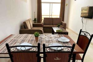 uma sala de estar com uma mesa e cadeiras e um sofá em Beautfiul Salalah Beach Apartment - Flat 404 em Salalah