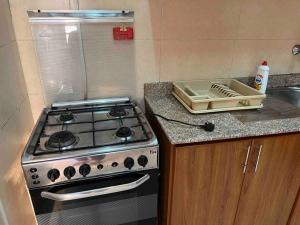 um balcão de cozinha com um fogão e um lavatório em Beautfiul Salalah Beach Apartment - Flat 404 em Salalah